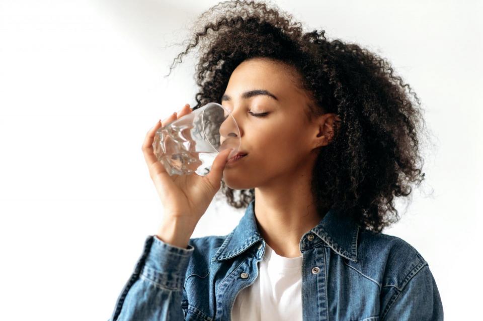 Woman enjoying glass water on national hydration day